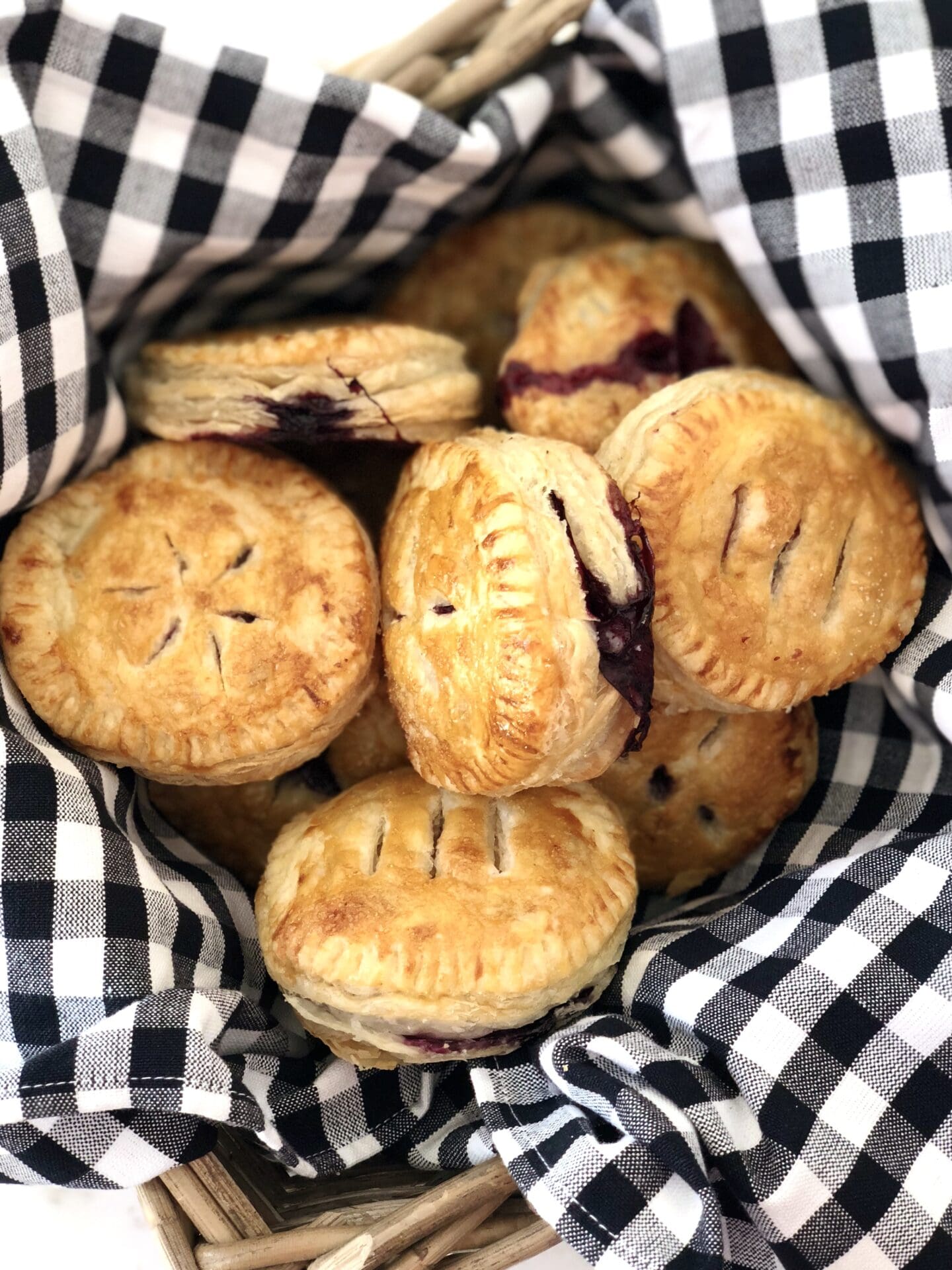 52EF4842-3B1D-4010-B7E8-7971AF07593F Basket of Blueberry hand pies at a picnic
