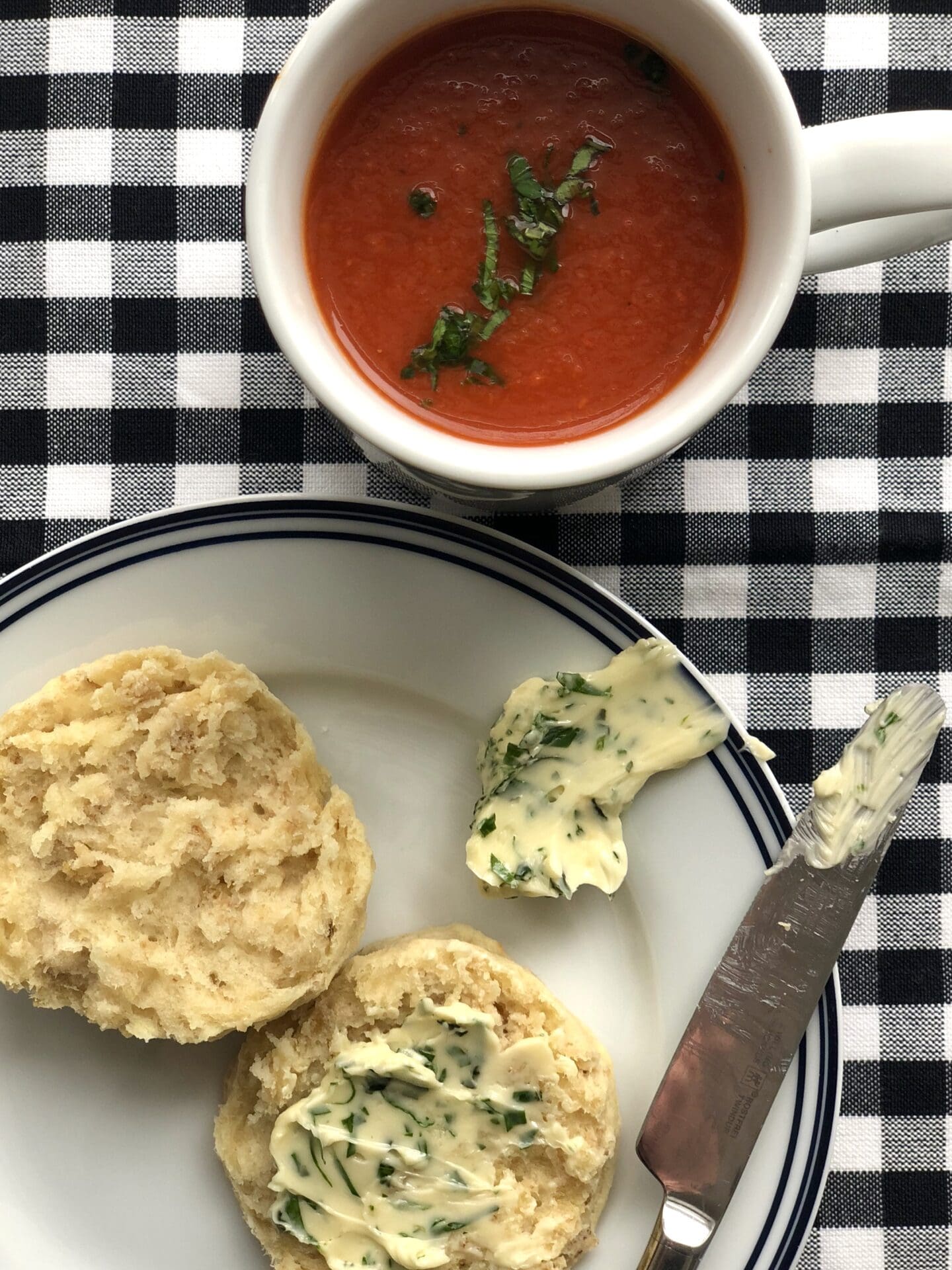 B620842D-FBB2-4186-A780-2B8AB340BEB2 A mug of homemade tomato soup with a warm biscuit and herb butter