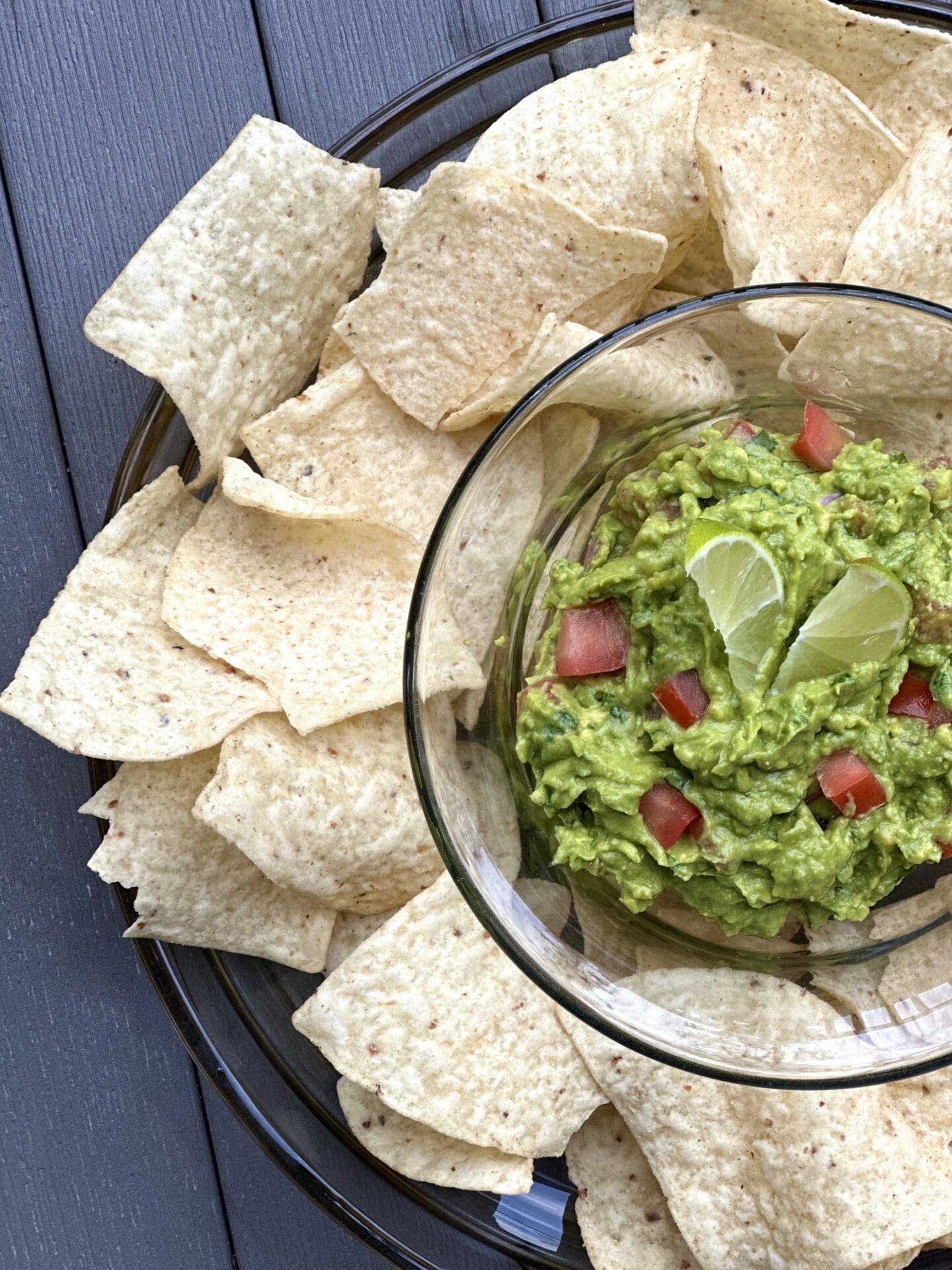 IMG_7781 A platter of chips and fresh homemade guacamole sitting on an outdoor patio table, seen from above.