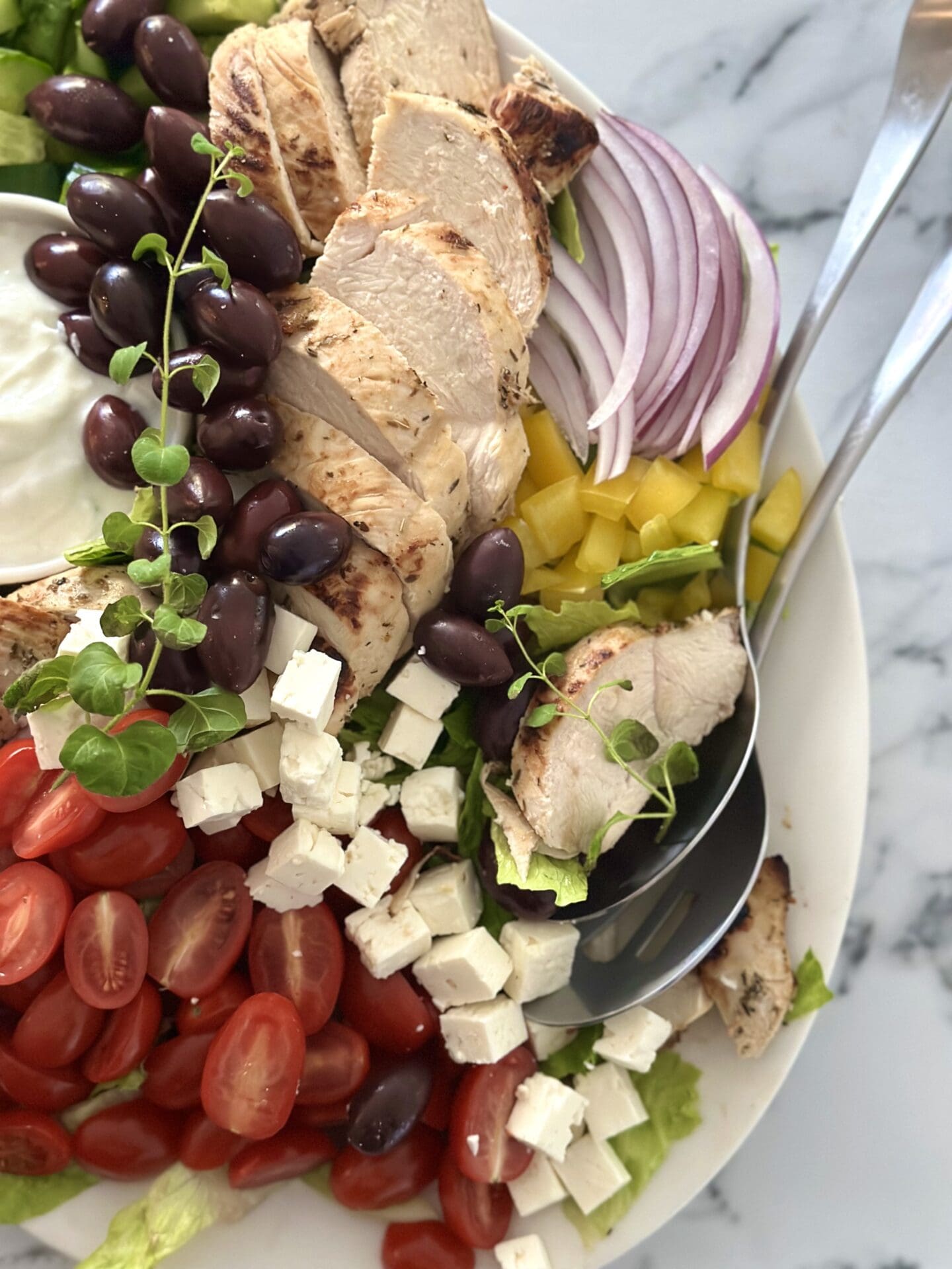IMG_0467 Serving spoons are placed on the edge of a big platter of Grilled Chicken Souvlaki Salad