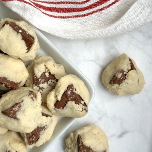 A platter of Toblerone shortbread cookies is seen from above on a white marble table