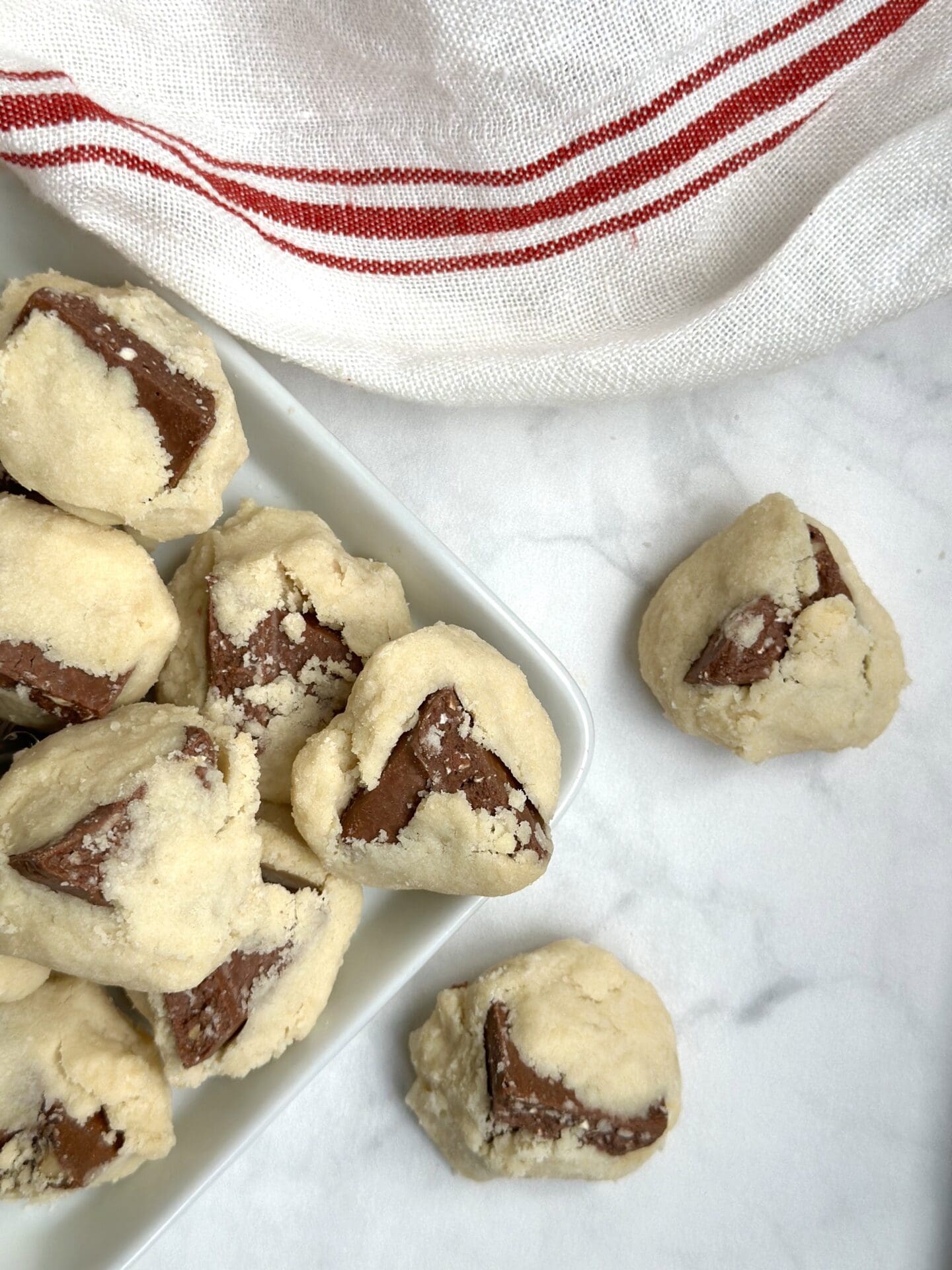A platter of Toblerone shortbread cookies is seen from above on a white marble table