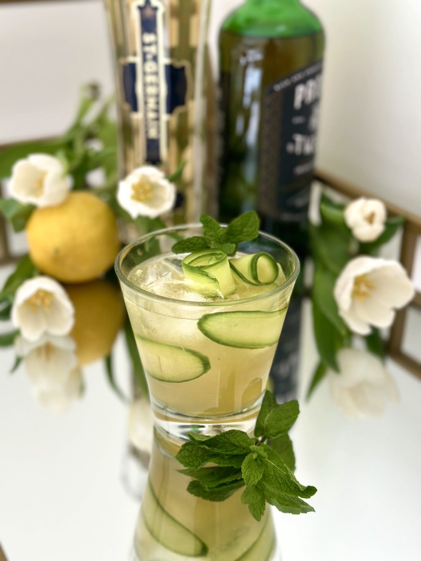 IMG_1338 An Irish Maid Cocktail sits on a sparkling bar with Elderflower Liqueur, Irish Whiskey, lemons and white tulips