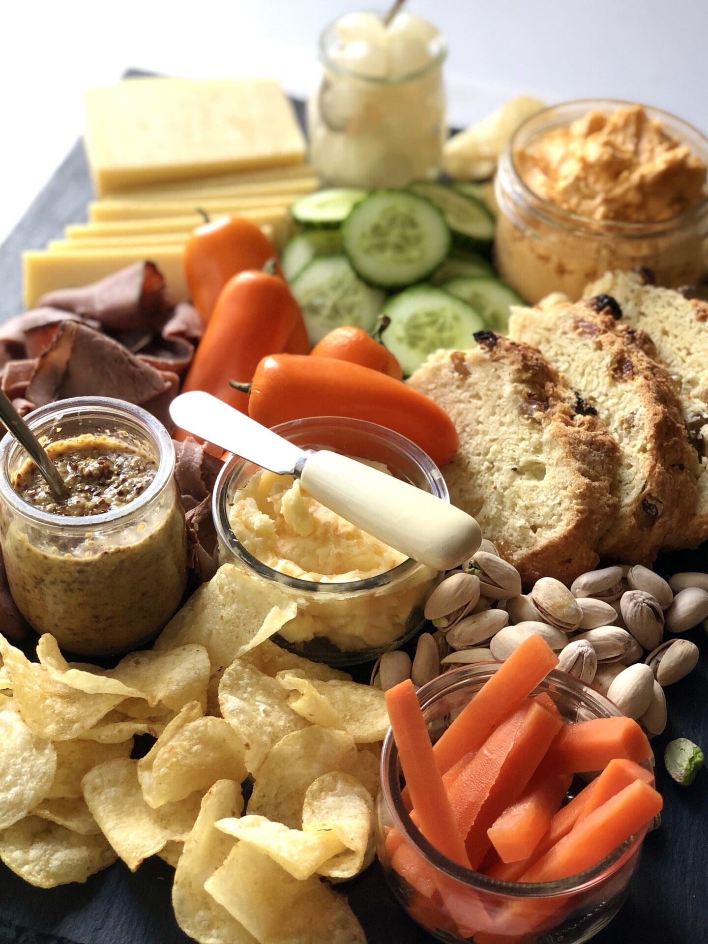 IMG_5719 A St Patrick's Day charcuterie board featuring Irish cheddar, roast beef, beer cheese, pickled carrots and Irish soda bread is seen from above.