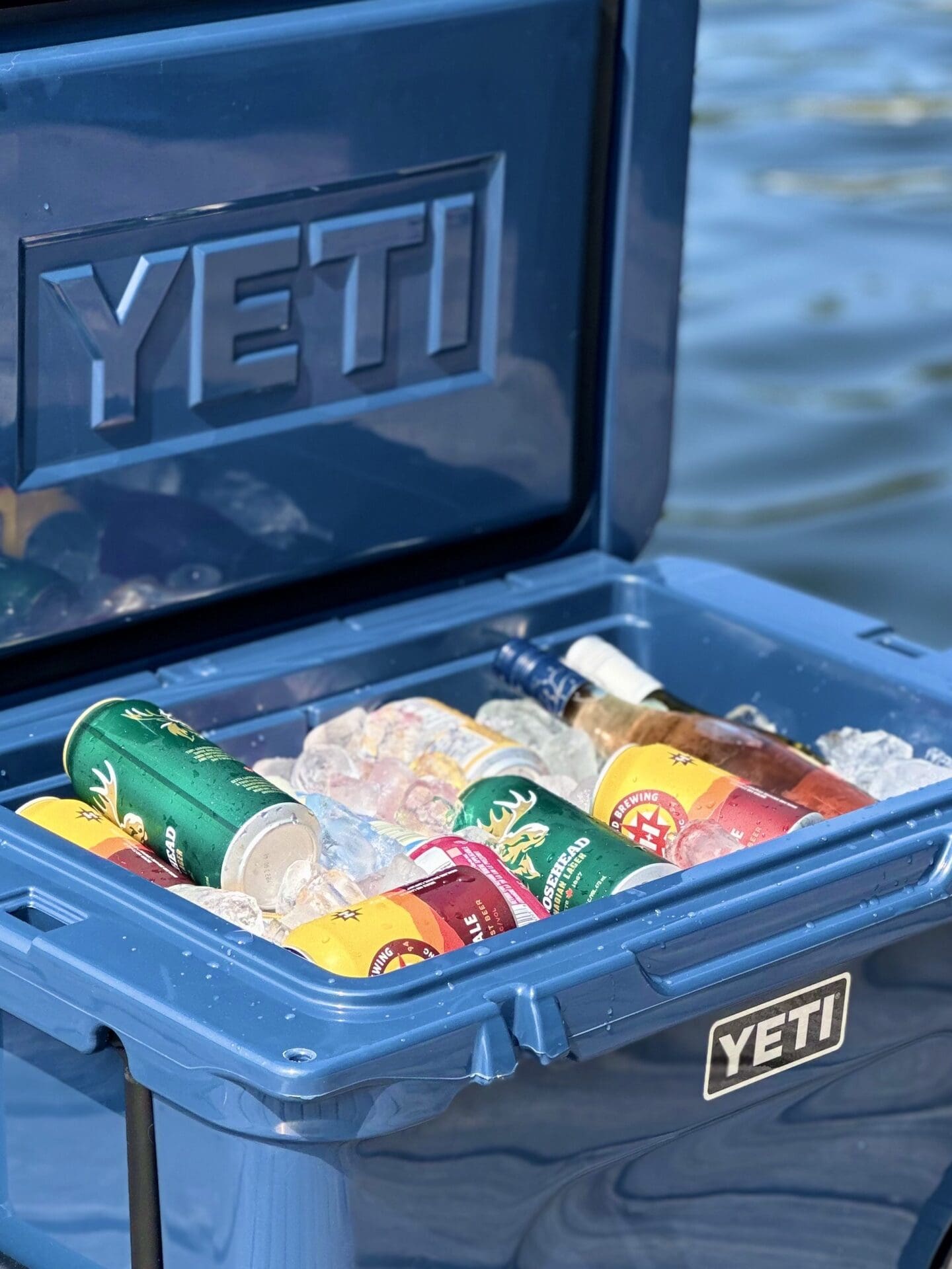 IMG_2673 A blue Yeti cooler filled with ice and cold drinks sits open on a dock by a lake