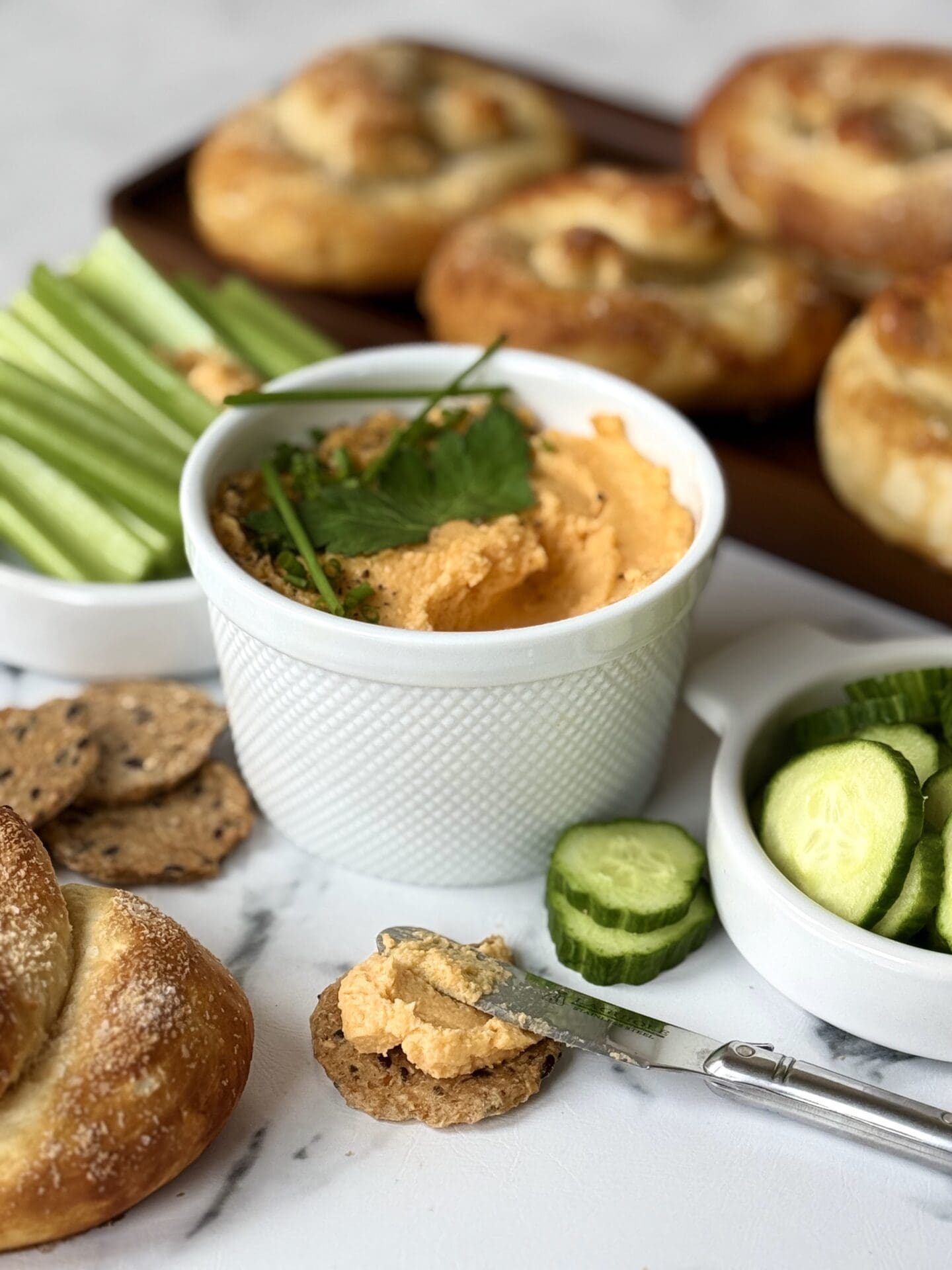 IMG_4641 A bowl of Pub Style Beer Cheese sits in the centre of the photo, surrounded by crackers, veggies and freshly baked soft pretzels.