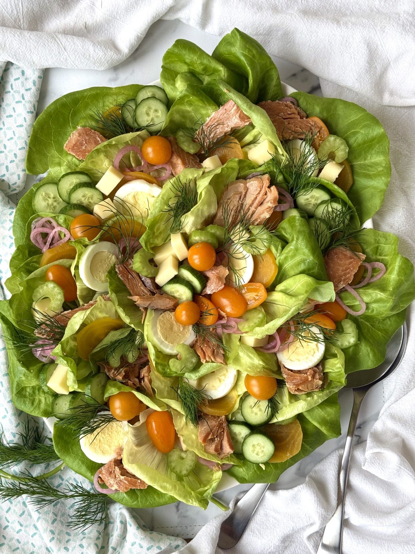 A full platter of Irish Pub Salad with Hot Smoked Salmon is seen from above, featuring fresh and pickled vegetables, eggs, Irish cheddar and chunks of hot smoked salmon.