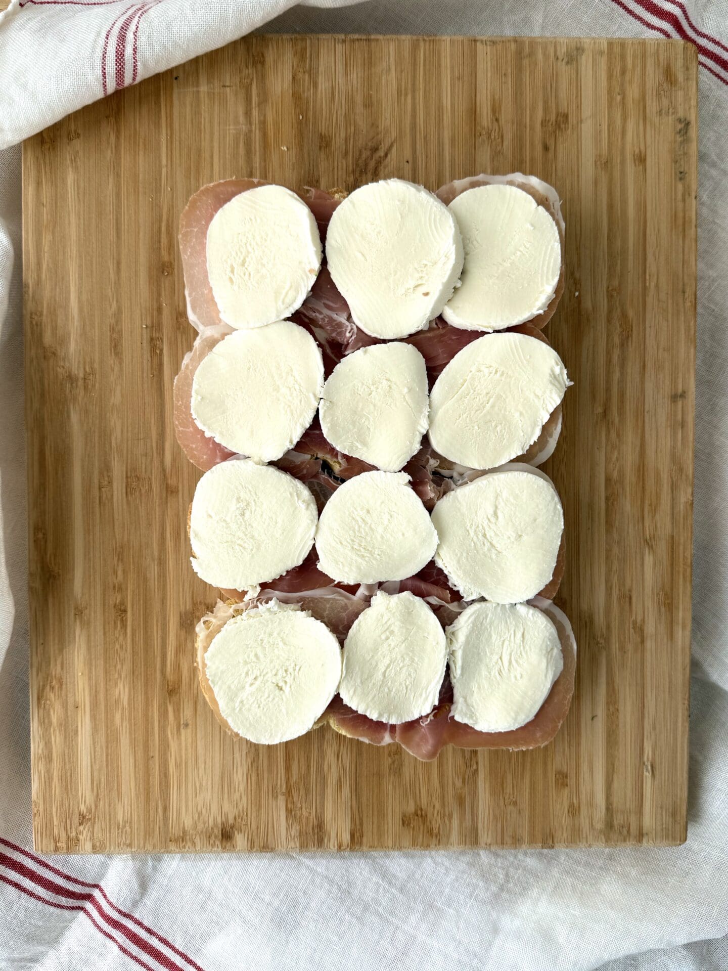 IMG_5004 Slices of fresh mozzarella cheese is layered on top of the prosciutto in the third step of building Italian Antipasto Sliders.
