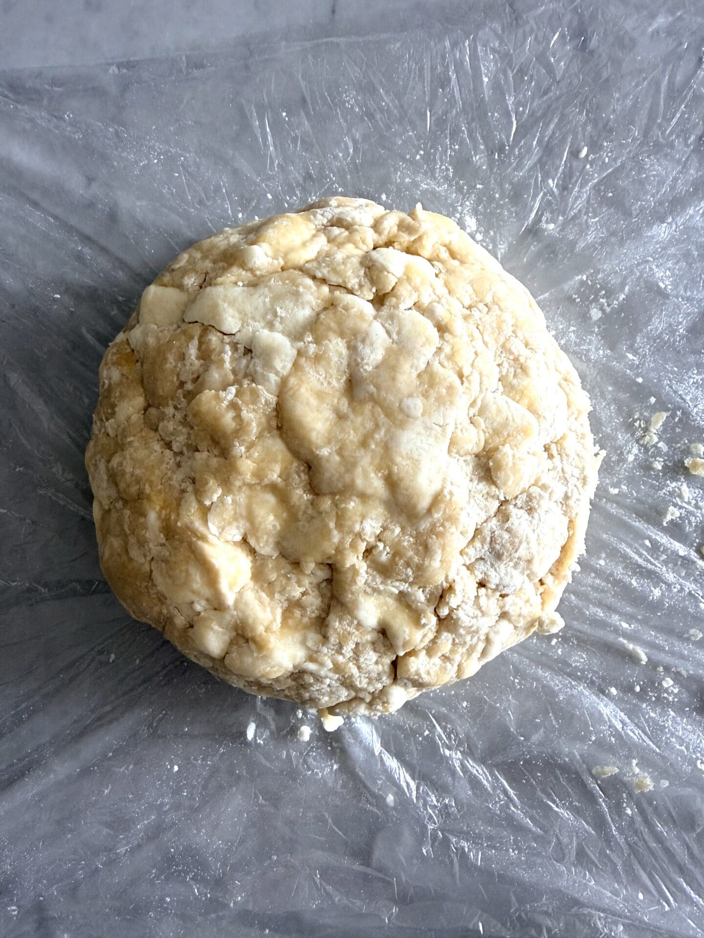 A ball of pastry dough is seen after it has rested and chilled in the swift.  The image shows a tighter, smoother shape than previously seen with the fresh dough.