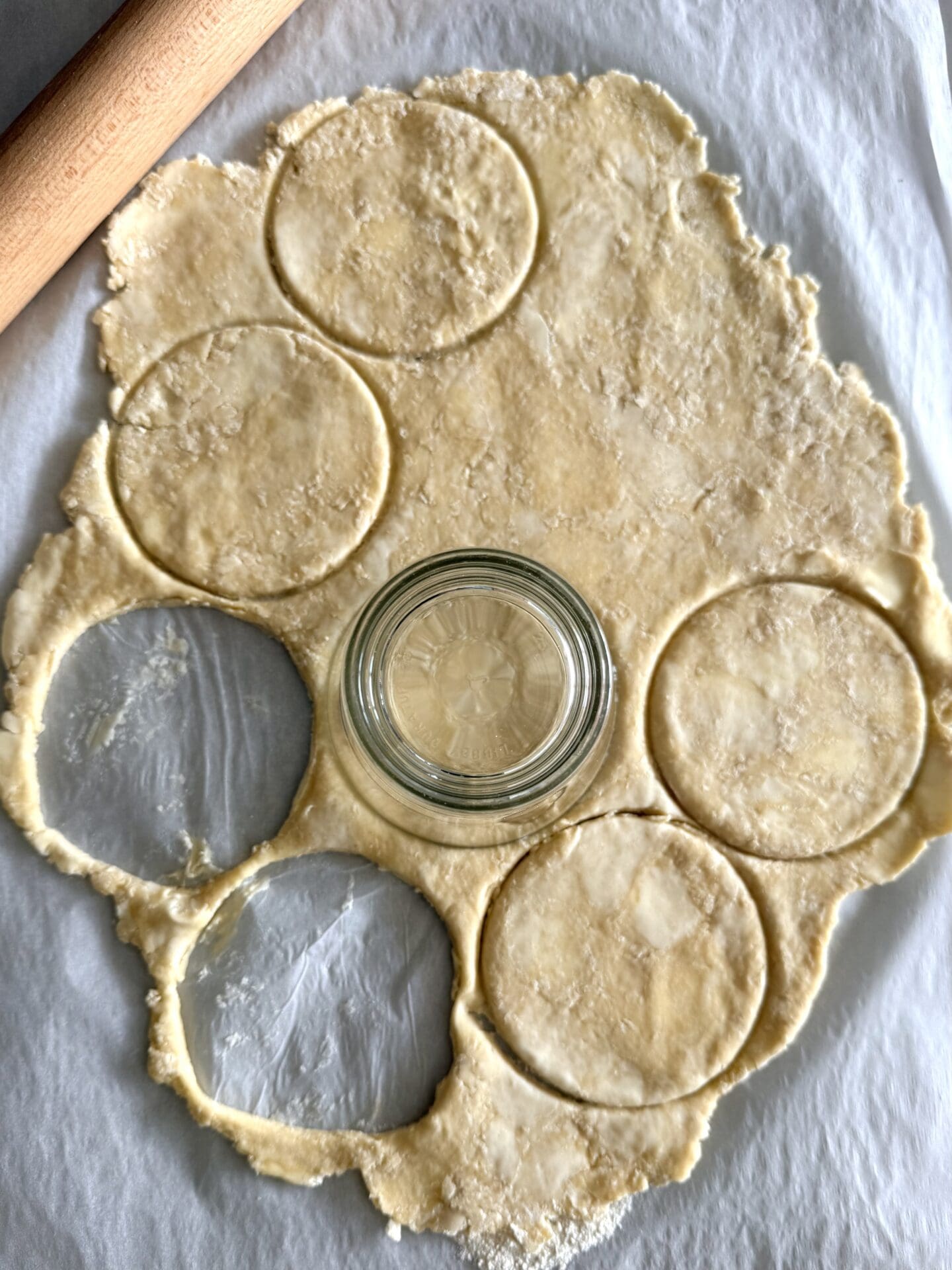Rounds of pastry are being cut out for butter tarts, using a drinking glass as a cutter.